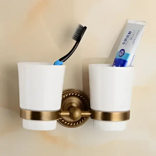 Antique brass bathroom set with ornate mounts and ceramic brush cup