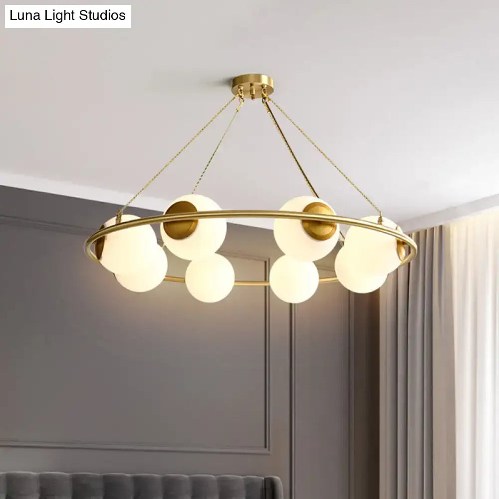 Modern brass ring chandelier with frosted glass spheres dining room
