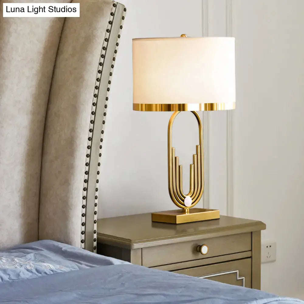 Minimalist gold paperclip table lamp with fabric drum shade for bedroom