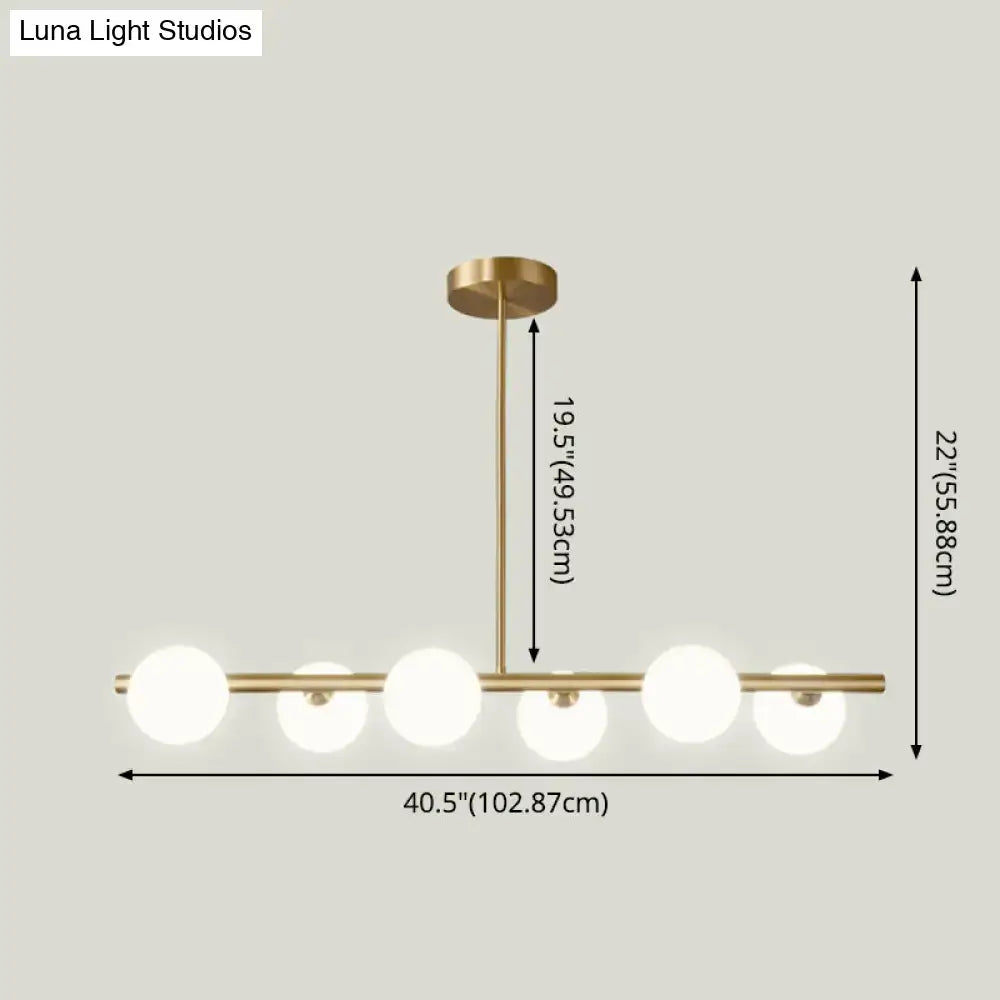 Modern brass 5-light pendant light with spherical glass shade dining room