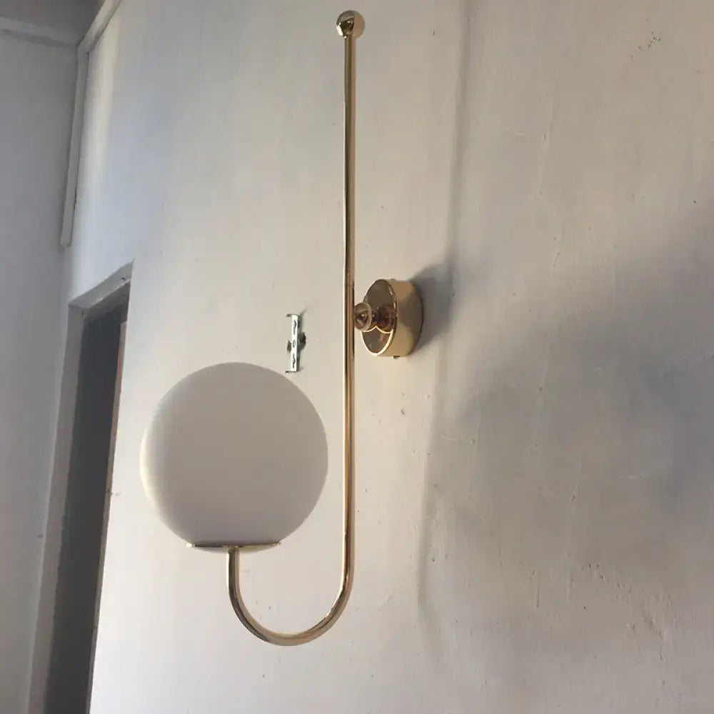 Modern golden gooseneck wall sconce with frosted glass ball bedroom