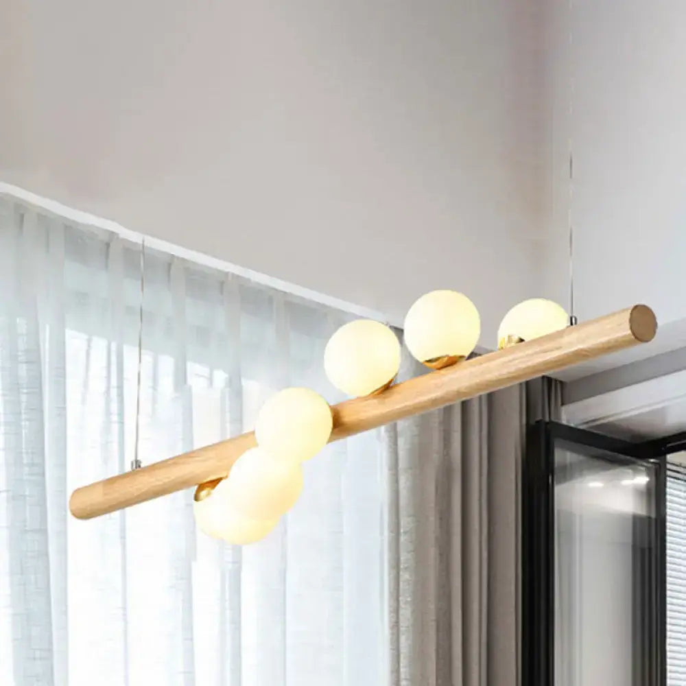 Modern wood island light with opal glass spheres for dining room