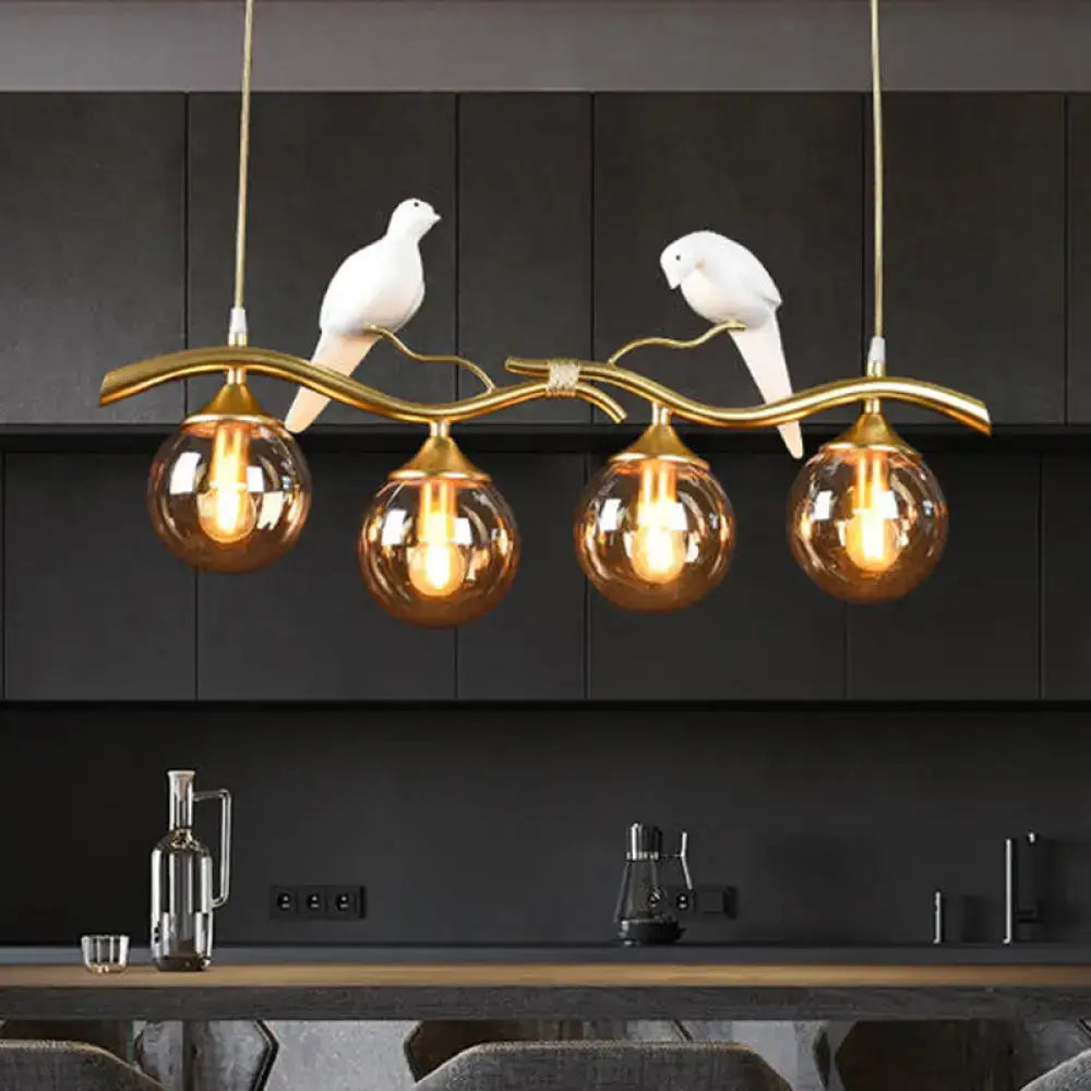 Postmodern black & gold bird pendant light with amber ball glass shade