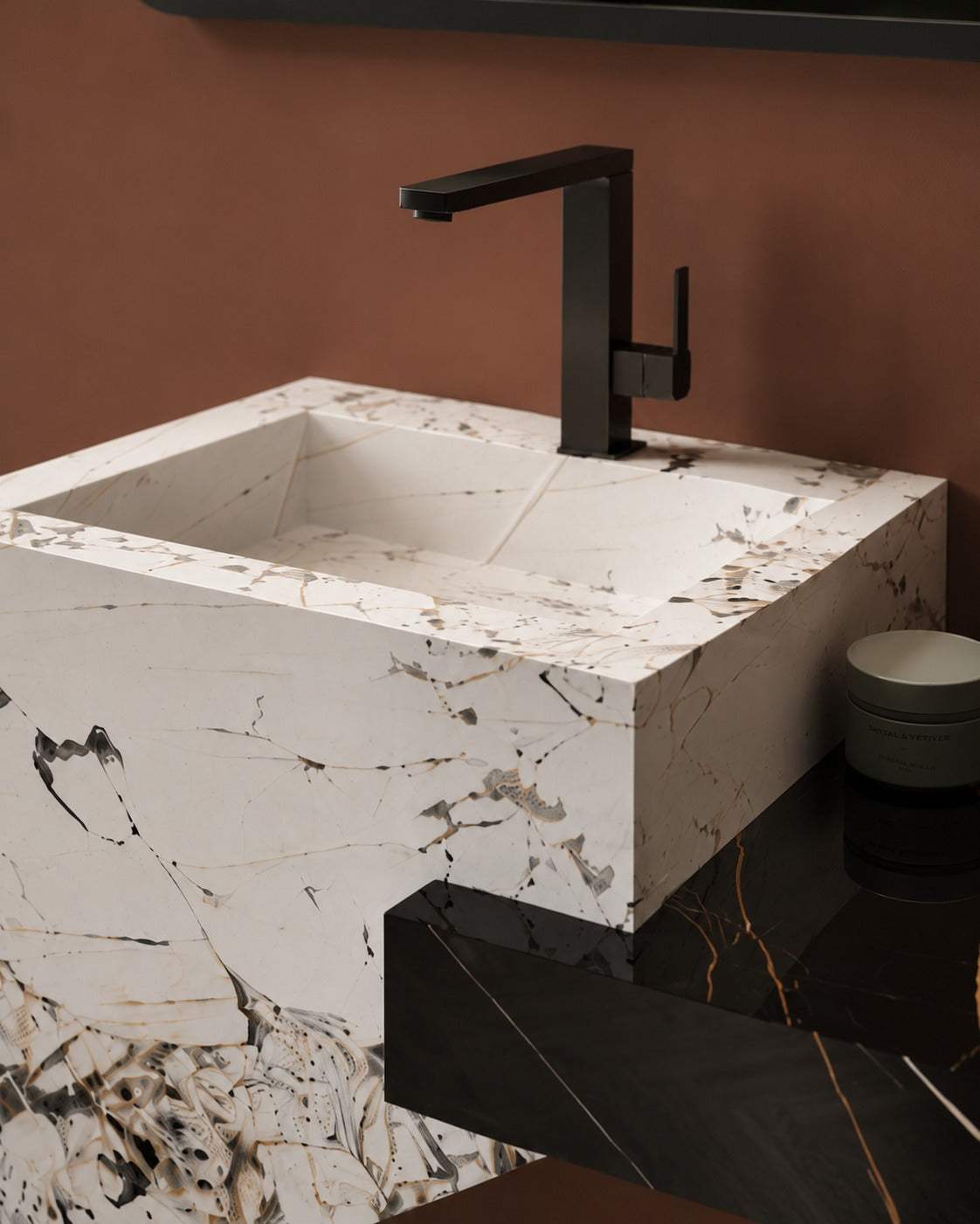 Marble sink with black faucet against a brown wall