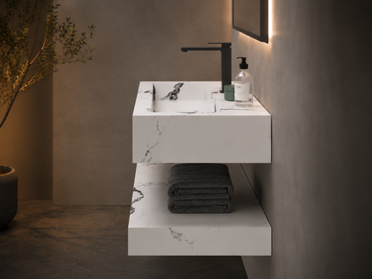 Modern bathroom vanity with sink, faucet, and towels against a neutral wall.