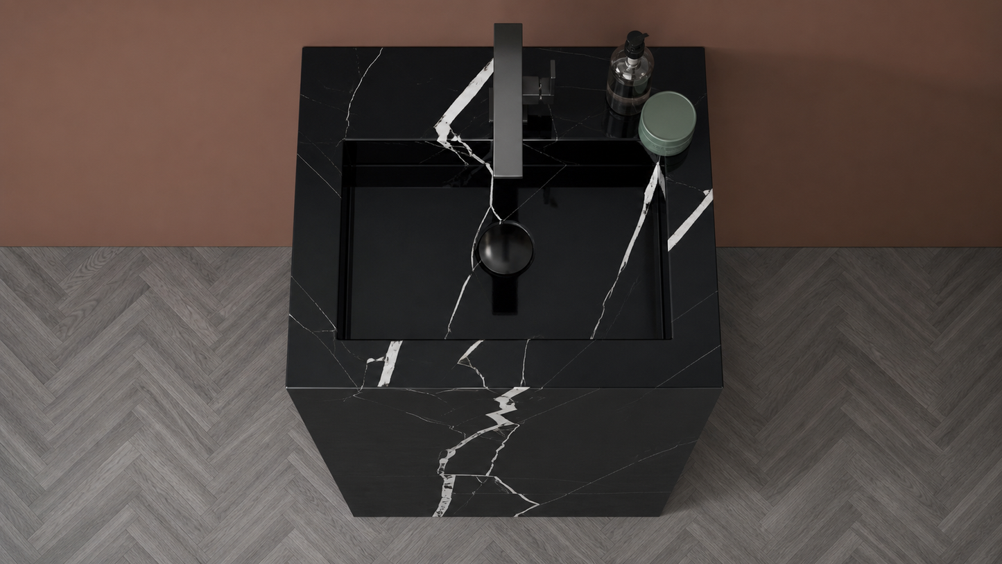 Black marble sink with faucet on a gray and brown patterned floor