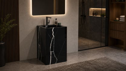 Modern bathroom with a black marble sink and illuminated mirror.