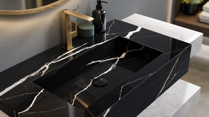 Black marble sink with gold faucet in a bathroom setting