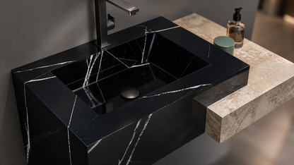 Black marble sink on a stone countertop with a blurred background