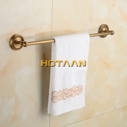 Antique brass single towel bar with ornate base for bathroom decor