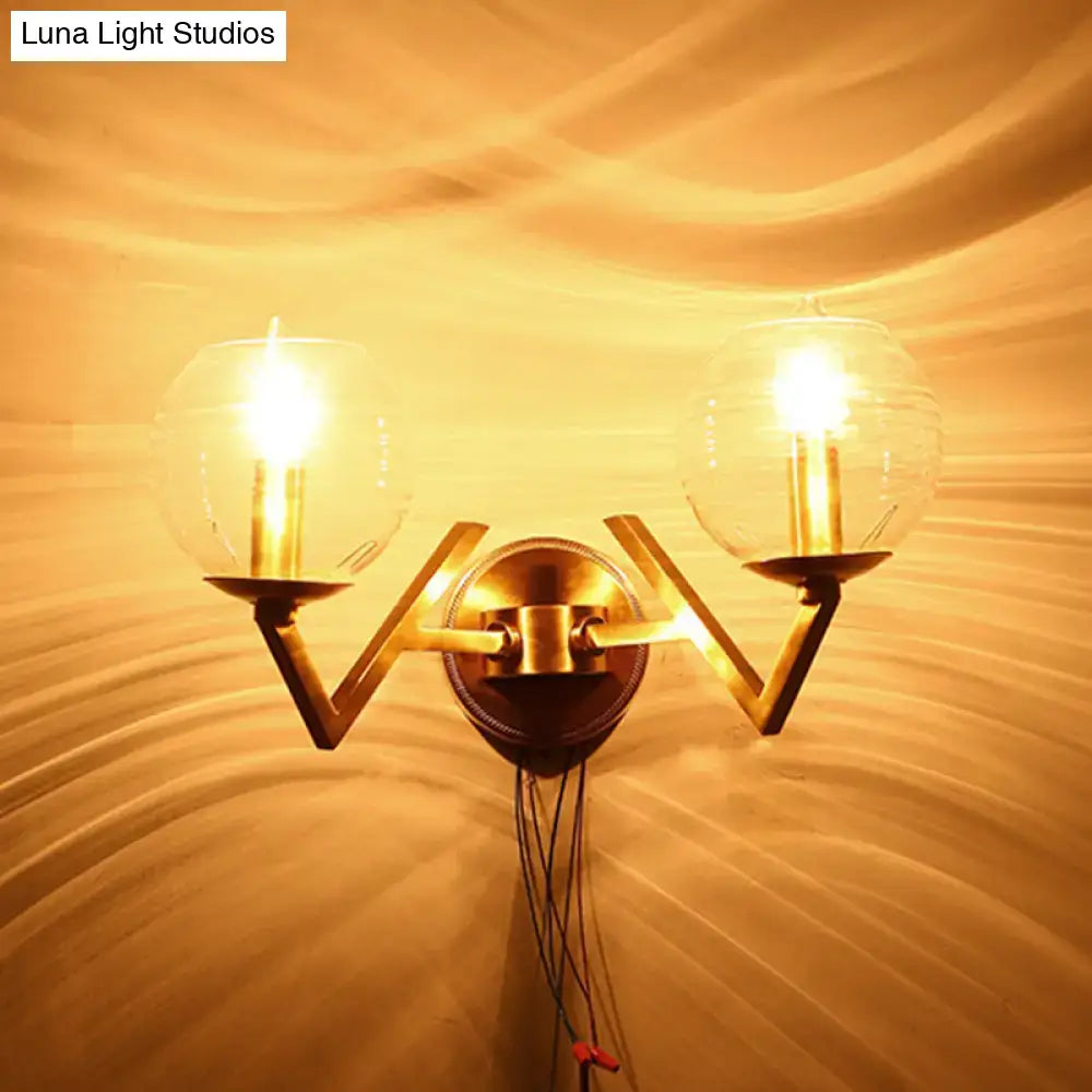 Brass ball sconce with ribbed glass shade for bedroom wall lighting
