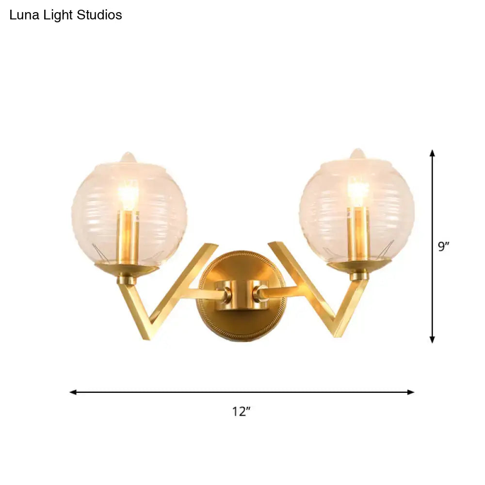 Brass ball sconce with ribbed glass shade for bedroom wall lighting