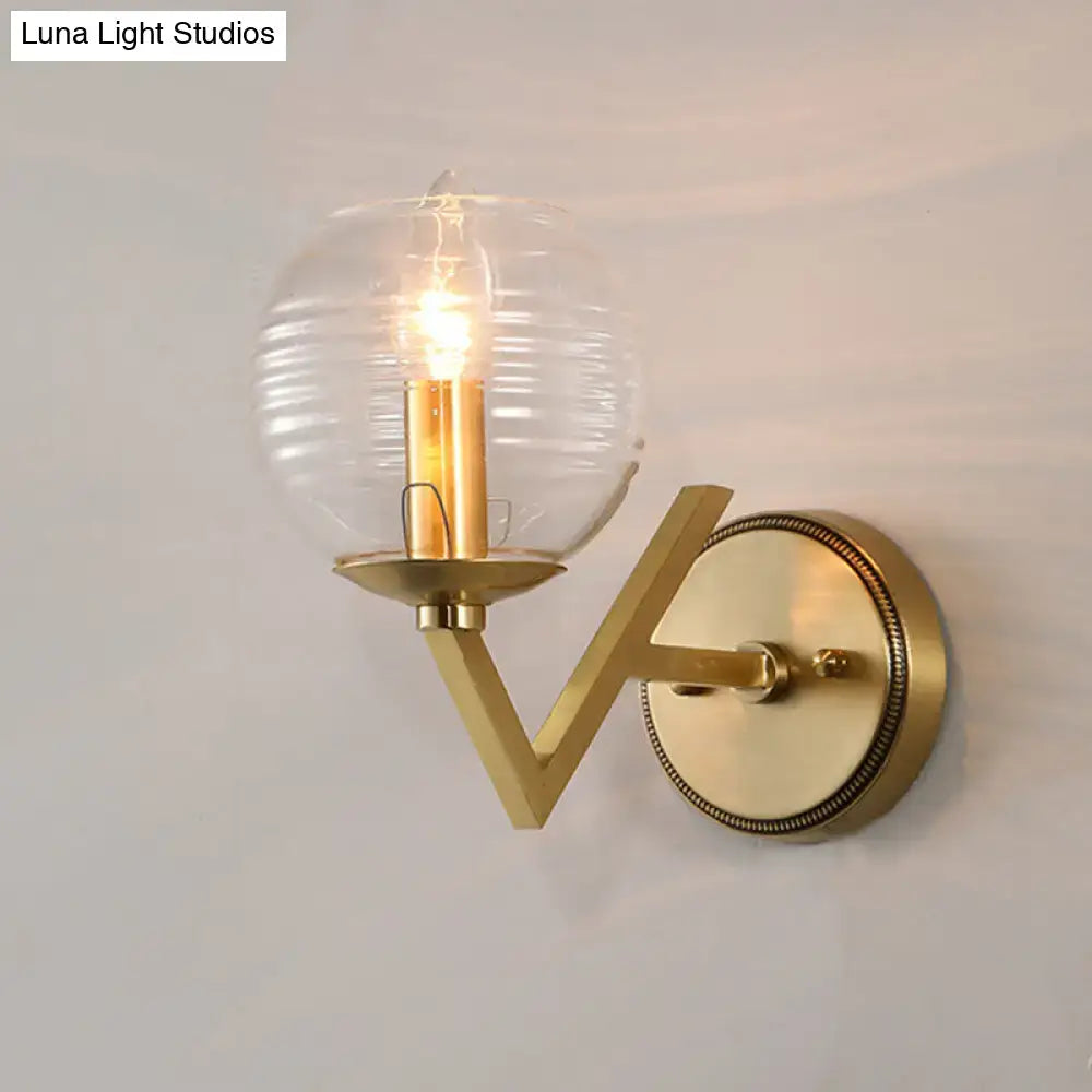 Brass ball sconce with ribbed glass shade for bedroom wall lighting