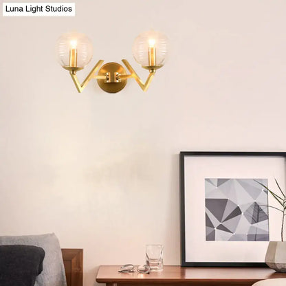 Brass ball sconce with ribbed glass shade for bedroom wall lighting
