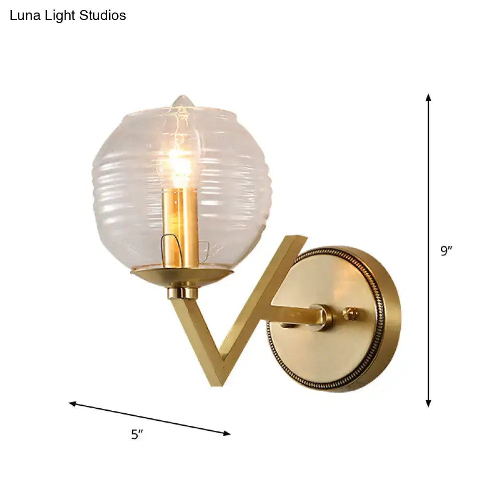 Brass ball sconce with ribbed glass shade for bedroom wall lighting