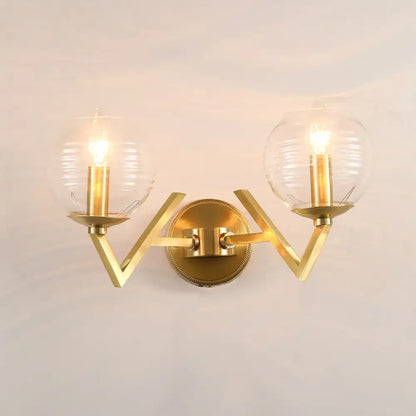 Brass ball sconce with ribbed glass shade for bedroom wall lighting
