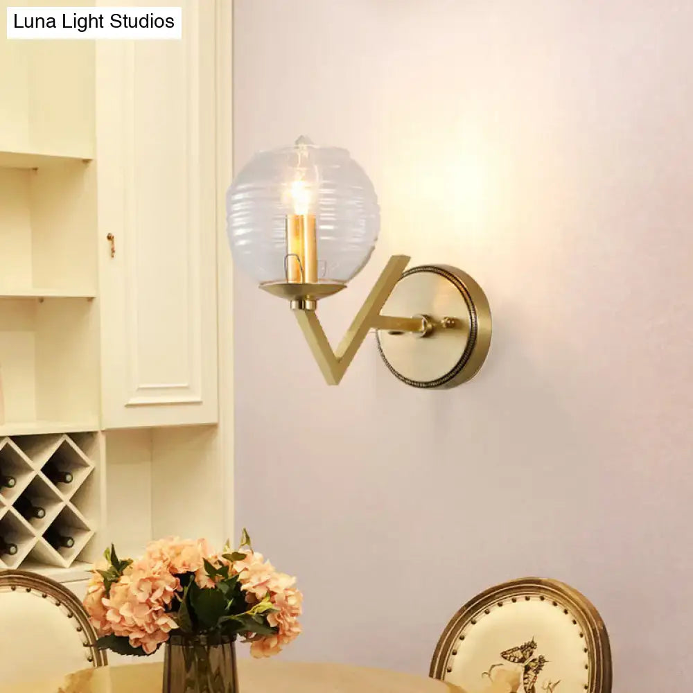 Brass ball sconce with ribbed glass shade for bedroom wall lighting