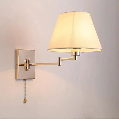Brushed nickel adjustable rocker arm wall lamp with cream shade bedroom