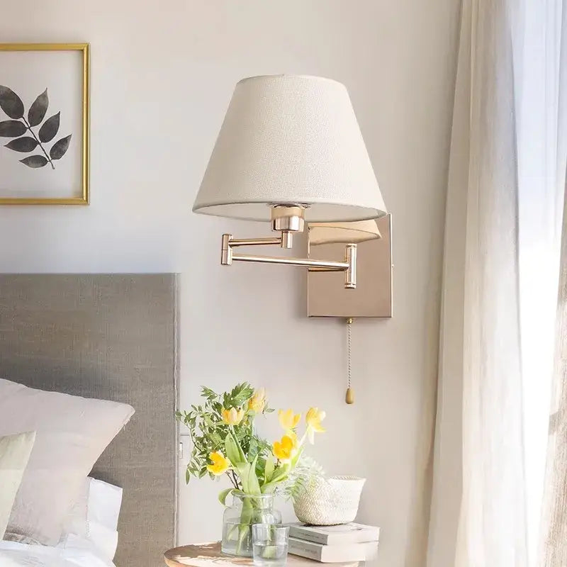 Brushed nickel adjustable rocker arm wall lamp with cream shade bedroom
