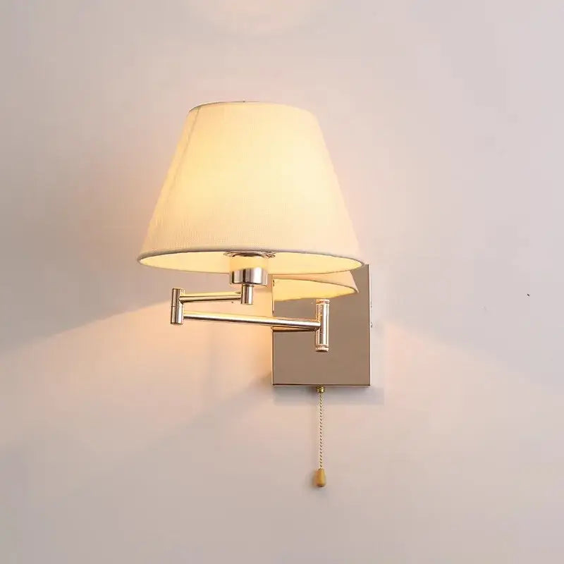 Brushed nickel adjustable rocker arm wall lamp with cream shade bedroom