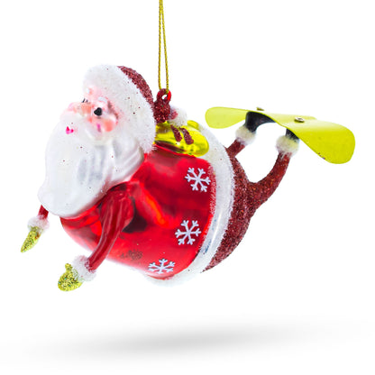 Santa Snowboarding Glass Christmas Ornament