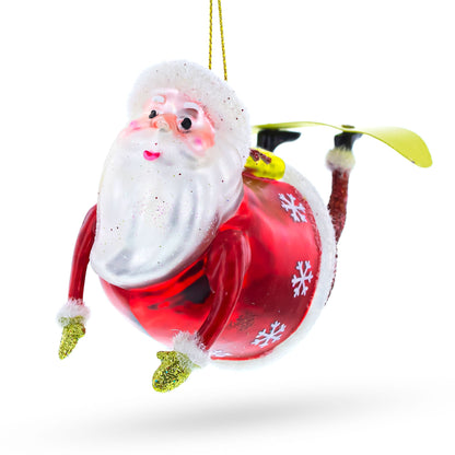 Santa Snowboarding Glass Christmas Ornament