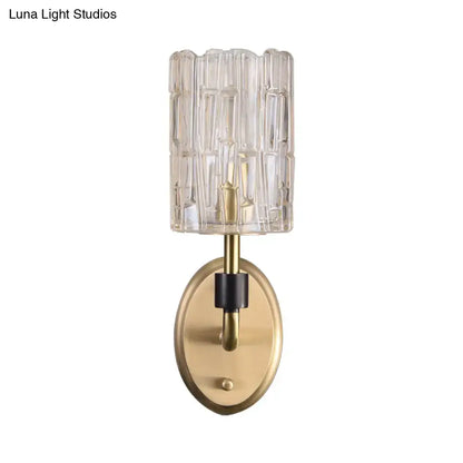Contemporary brass bedside wall sconce with clear crystal shade bedroom