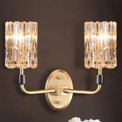 Contemporary brass bedside wall sconce with clear crystal shade bedroom