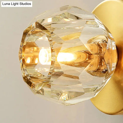 Contemporary golden wall mount lamp with faceted glass shade living room