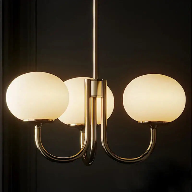 Cream pink bedroom pendant light with three glass globes and brass