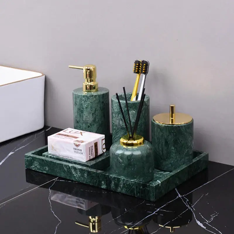 Dark green marble bathroom accessory set with gold accents