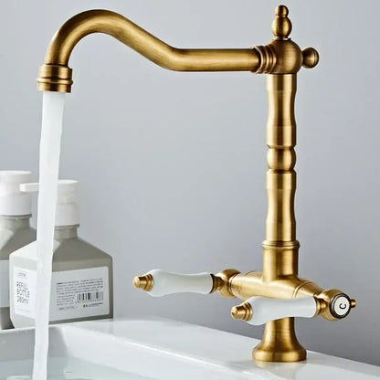 Antique brass kitchen faucet with ceramic handles and curved spout