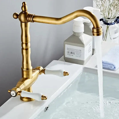 Antique brass kitchen faucet with ceramic handles and curved spout