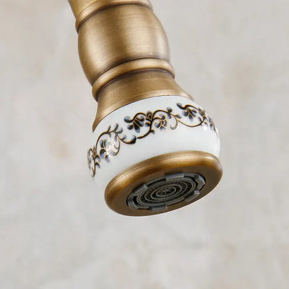 Antique brass swivel spout kitchen faucet with floral ceramic handle