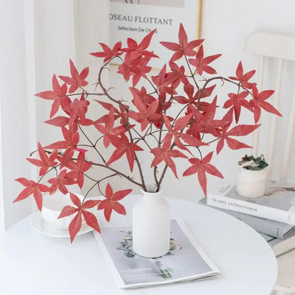 Vibrant red artificial maple leaf bouquet in white vase living room