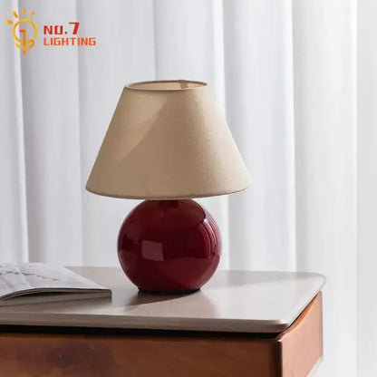 Red ceramic table lamp with beige shade for bedroom