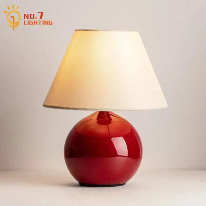 Red ceramic table lamp with beige shade for bedroom