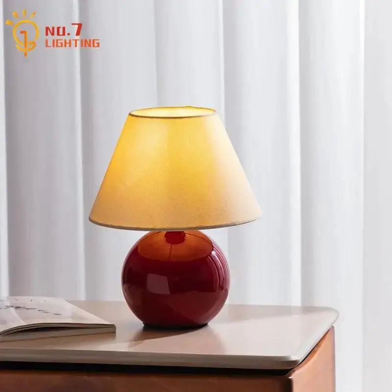 Red ceramic table lamp with beige shade for bedroom