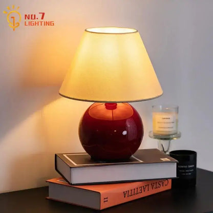 Red ceramic table lamp with beige shade for bedroom