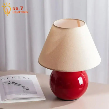 Red ceramic table lamp with beige shade for bedroom