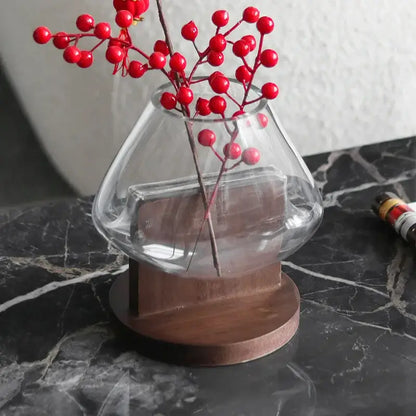 Minimalist clear glass vase with red berries and wood base living room