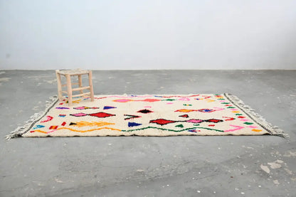 Handmade beige azilal rug with colorful geometric patterns bedroom