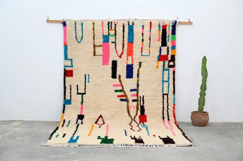 Beige moroccan azilal rug with vibrant geometric patterns bedroom decor
