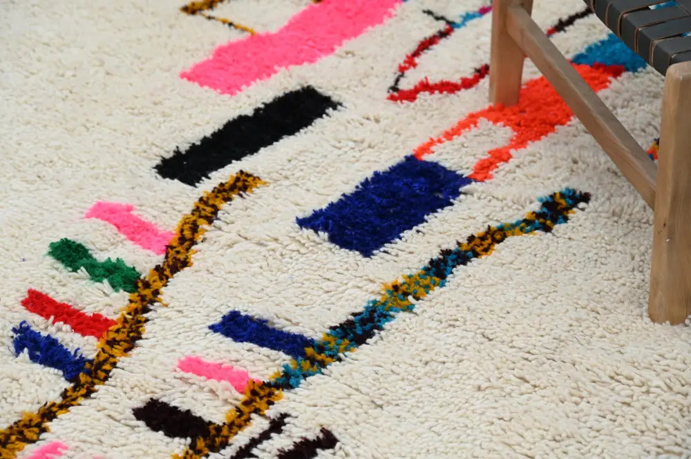 Beige moroccan azilal rug with vibrant geometric patterns bedroom decor