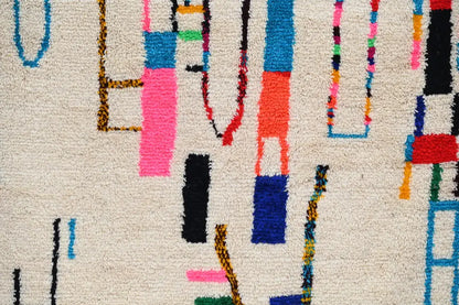 Beige moroccan azilal rug with vibrant geometric patterns bedroom decor