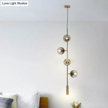 Modern gold linear chandelier with gray glass shades dining room
