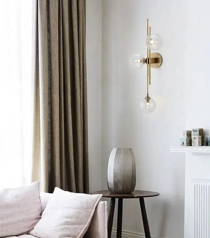 Modern gold wall sconce with textured glass globes for bedroom