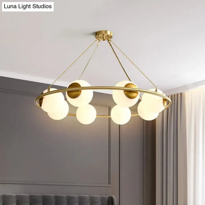 Modern brass ring chandelier with frosted glass spheres dining room