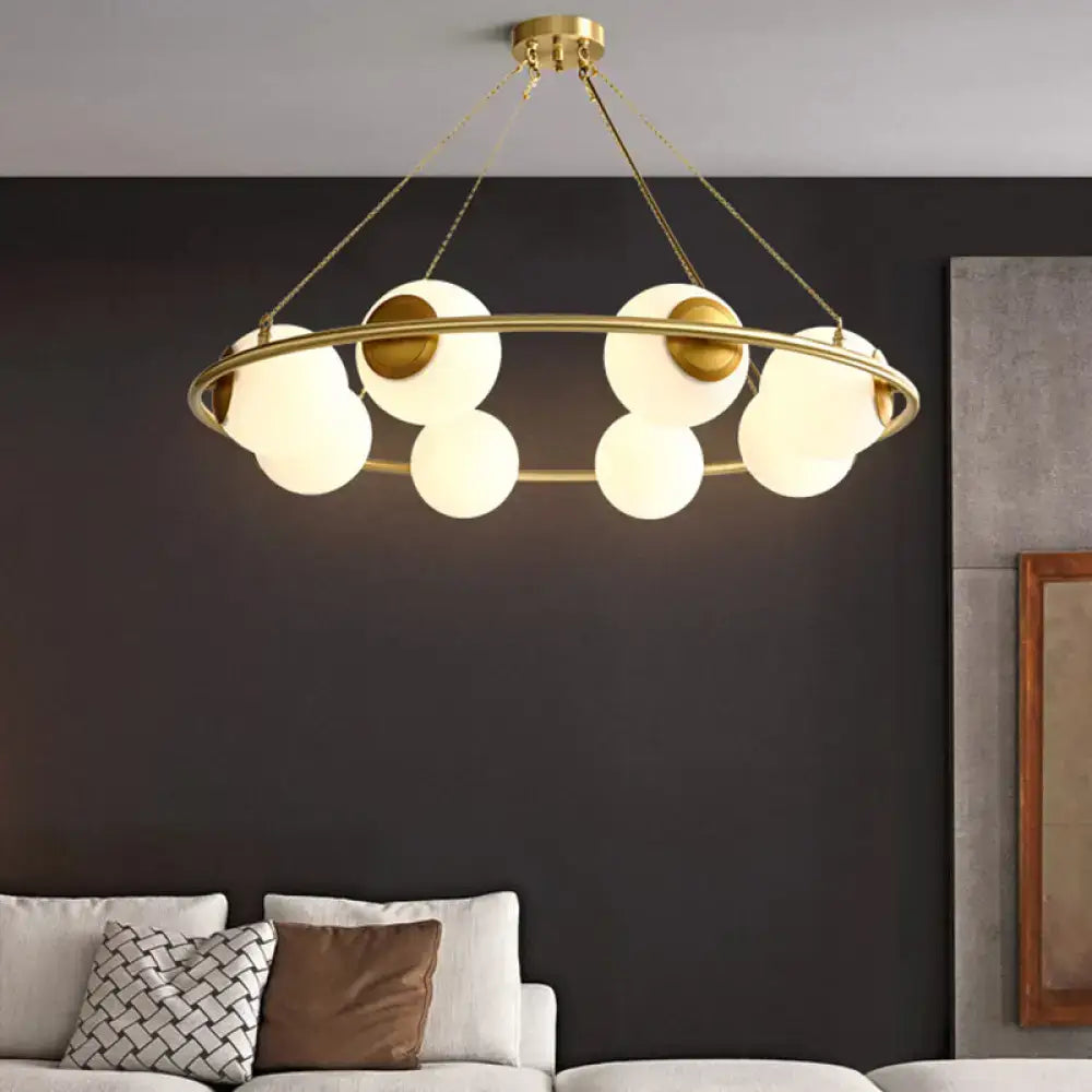Modern brass ring chandelier with frosted glass spheres dining room