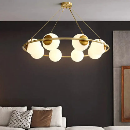 Modern brass ring chandelier with frosted glass spheres dining room